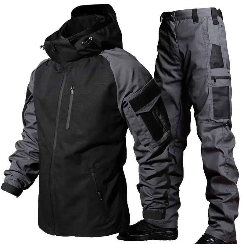 Black and gray tactical soft shell jacket with hood features multiple zippered pockets and reinforced fabric panels.