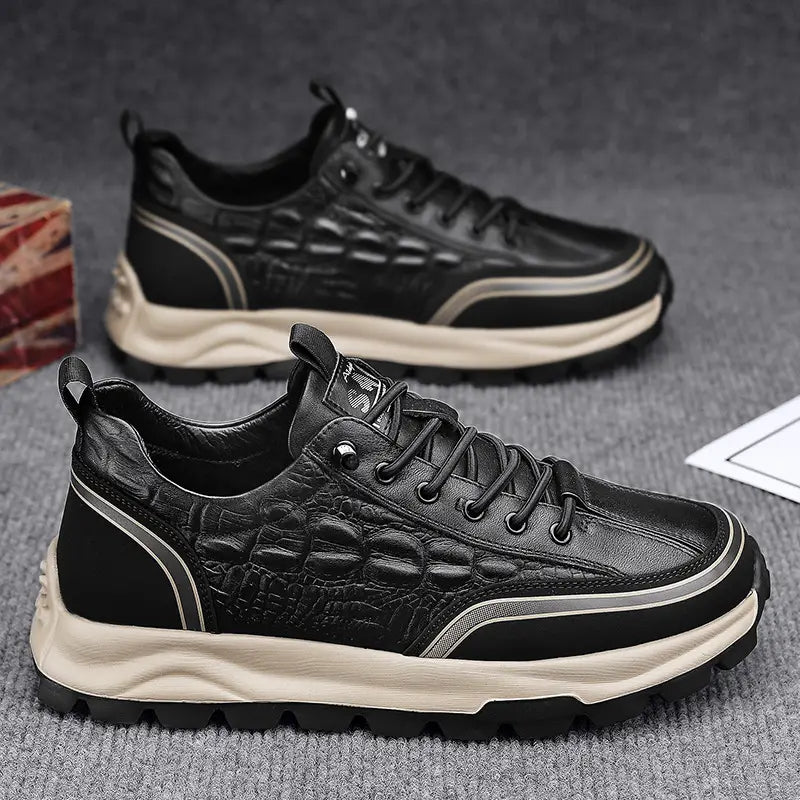 Men’s black crocodile embossed leather sneakers with a cream-colored chunky sole and silver accent stripes.