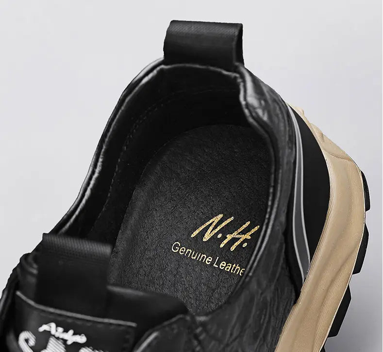 Men’s black crocodile embossed leather sneaker with a tan rubber sole and gold lettering on the insole reading n.h.