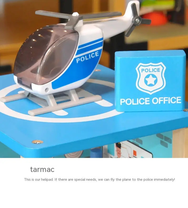 un hélicoptère de police-jouet en plastique bleu et blanc avec cockpit transparent inclus, dans un jeu d’ensemble caserne de pompiers et poste de police en bois pour enfants