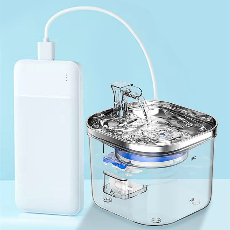 Fuente de agua para gatos de acero inoxidable con plástico transparente, con capa de filtración azul conectada a una batería de alimentación blanca mediante un cable de carga curvado para la dispensación automática de mascotas.