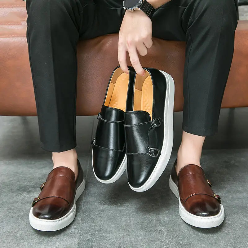 Baskets en cuir pour homme style business casual à double boucle en noir et marron, avec semelles blanches et un design enfîlable.