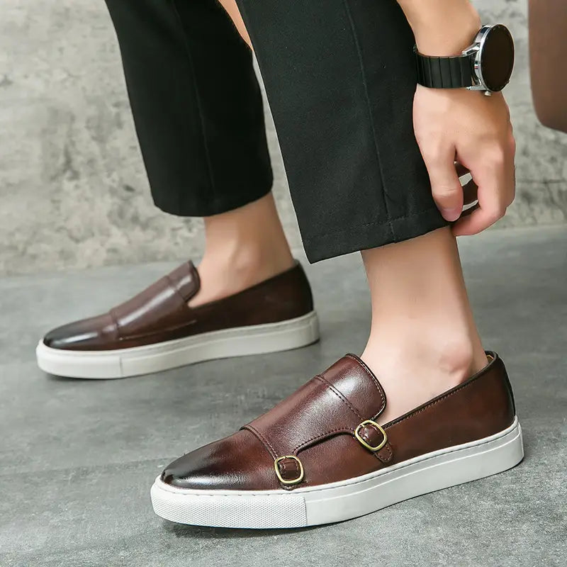 Baskets en cuir pour homme style business casual à double boucle présentant un design de mocassin enfîlable en cuir marron, un embout verni et deux brides de boucle ton or.