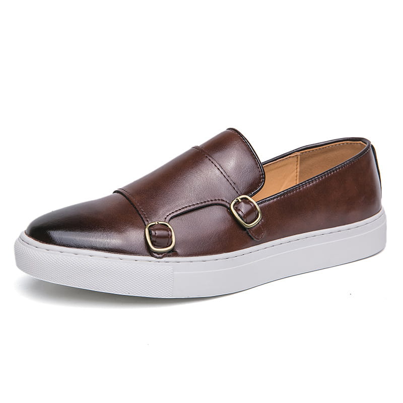 Baskets en cuir pour homme style business casual à double boucle présentant un cuir marron enfîlable, deux fermetures à boucle ton or et une semelle en caoutchouc blanc.
