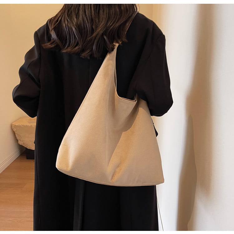 Beige canvas suede shoulder bag with large capacity and minimalist slouchy tote design.