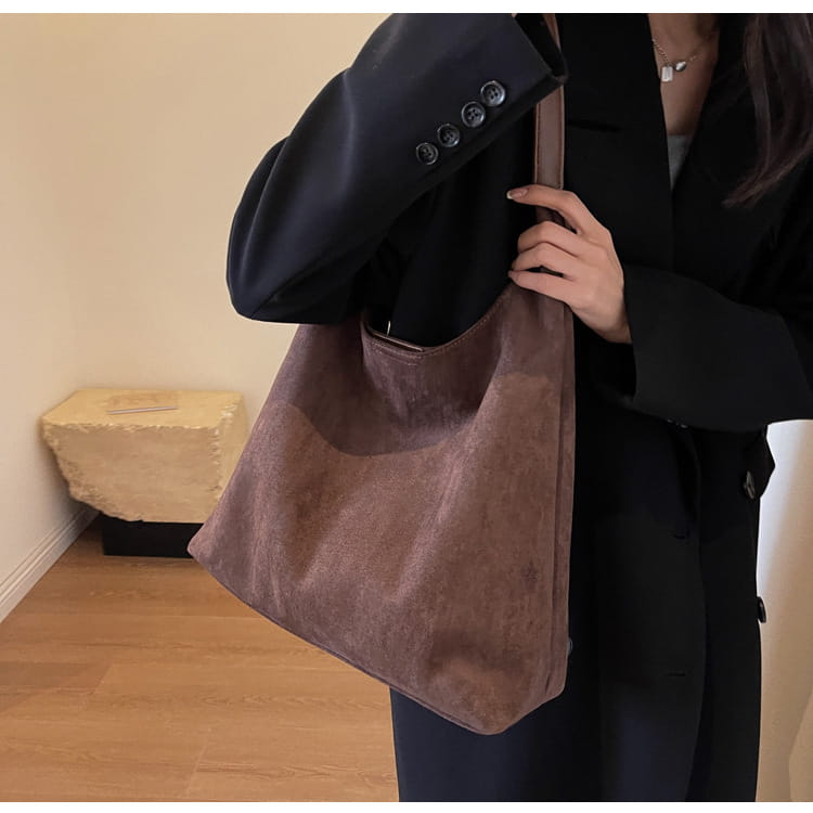 A soft dusty rose suede shoulder bag with a slouchy silhouette and large capacity suitable as a tote bag.