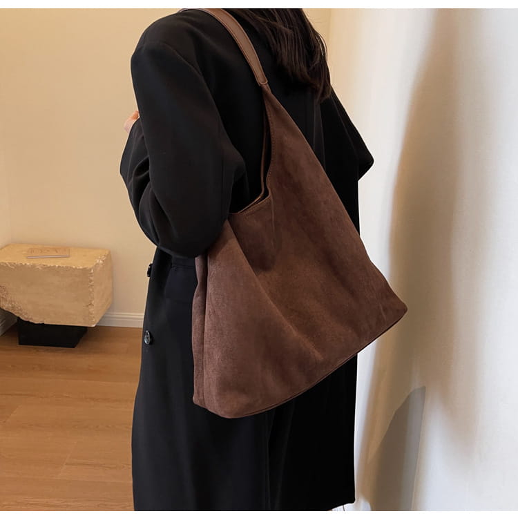 Brown suede shoulder bag with large capacity and soft slouchy design suitable for everyday use.