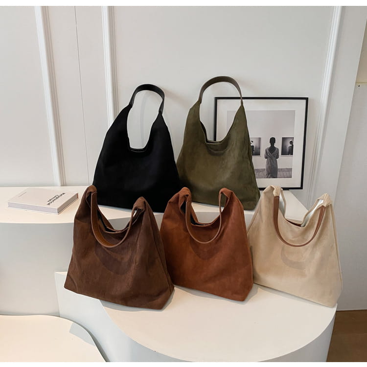 a collection of five suede shoulder bags in black olive green brown and beige featuring large capacity and slouchy tote design for versatile use