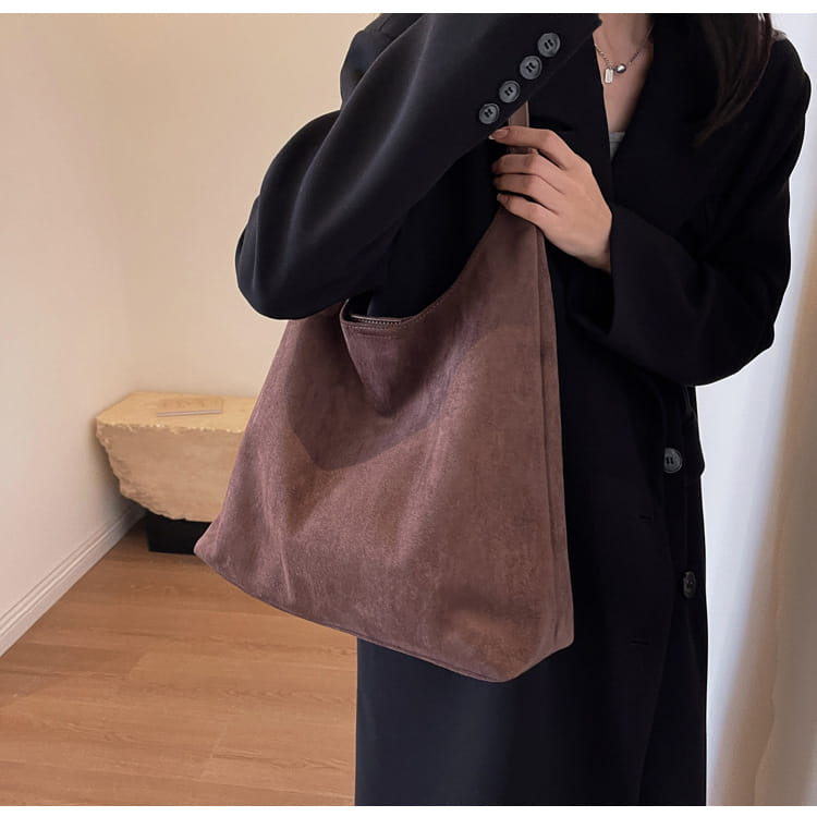A soft dusty rose suede shoulder bag large capacity slouchy tote bag with a minimalist design and top zipper closure.