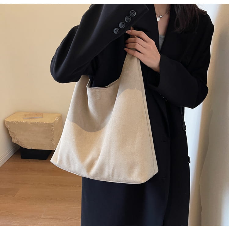 Beige canvas suede shoulder bag with a soft slouchy design and a single shoulder strap offering large capacity tote functionality.