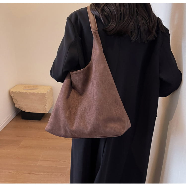 A soft brown suede shoulder bag with a simple minimalist design and large capacity slouchy tote style.