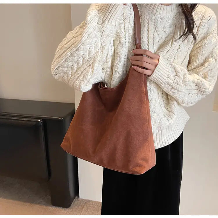 A cozy brown suede shoulder bag with a large capacity and soft slouchy design featuring a single strap.