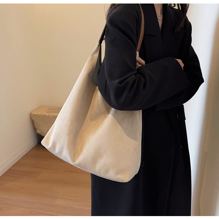 Beige canvas suede shoulder bag with large capacity slouchy tote design and brown leather straps.