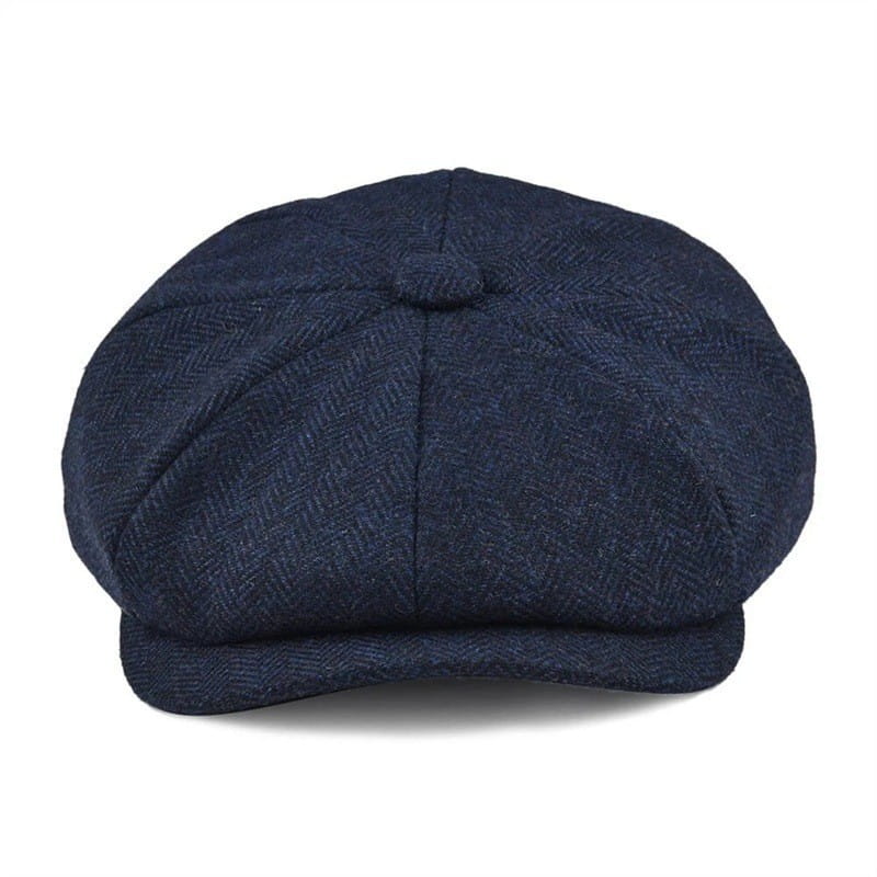 Dark blue herringbone-patterned woolen flat cap with a structured eight-panel design and a small button at the top for men.