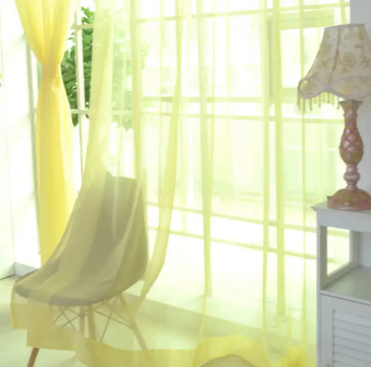 Sheer tulle window curtains in yellow with a delicate flowing design suitable for living room and bedroom use.