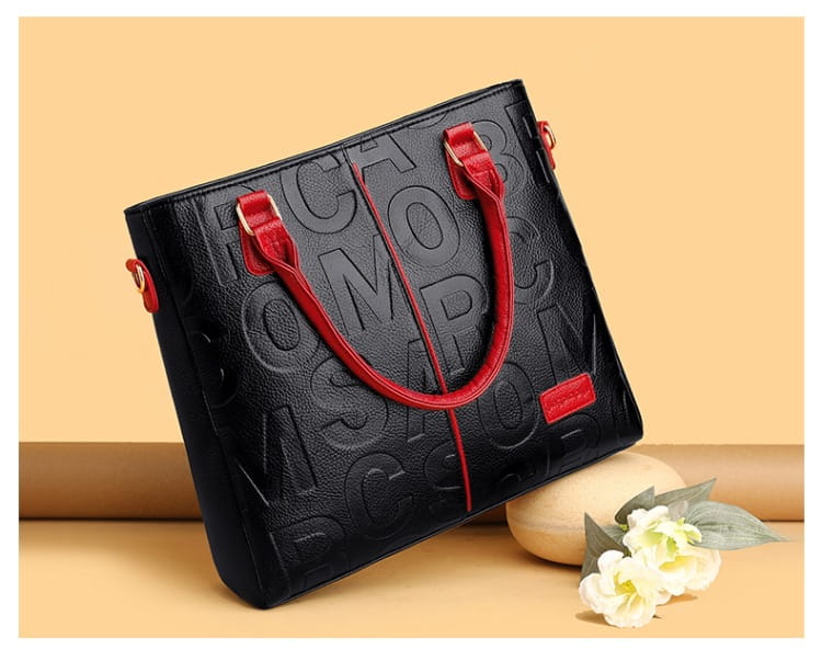 Black leather tote bag with bold red handles and subtle embossed Moschino logo pattern large capacity leather embossed shoulder bag.