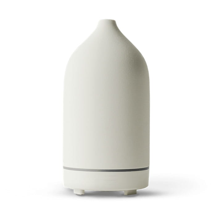 Cream-colored ceramic ultrasonic aroma diffuser and humidifier with a sleek tapered design and subtle silver accent band near the base.
