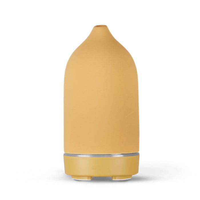 A sleek matte mustard-yellow ceramic ultrasonic aroma diffuser and humidifier with a rounded droplet shape and a silver accent band near its base.