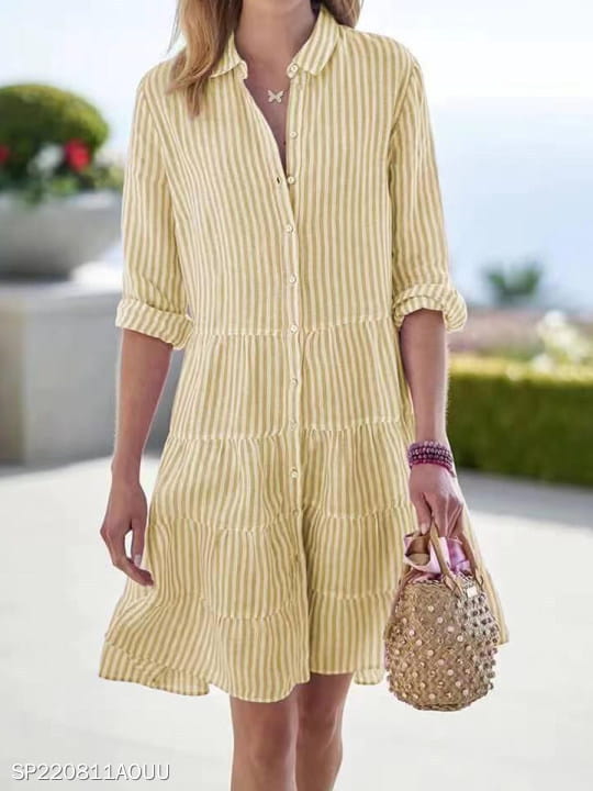 Robe chemise à volants étagés rayée verticalement jaune et blanc, avec col à revers et manches retroussées.