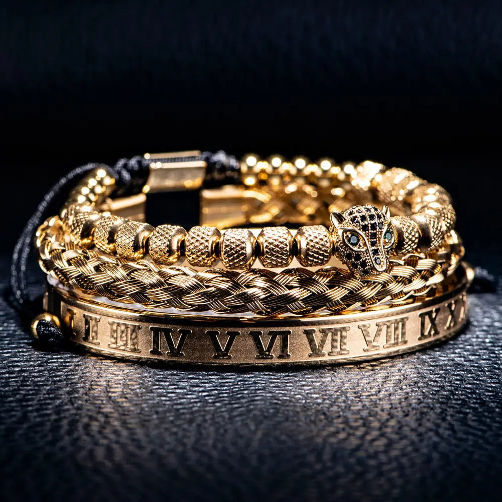 Golden braided leather bracelet set featuring a wolf head charm with blue eyes and roman numeral engraving.