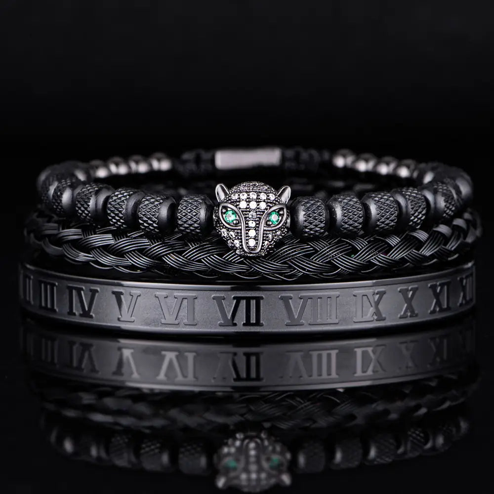 Black braided leather bracelet set featuring a silver-toned panther head charm with green gemstone eyes and diamond-like inlays accented by textured black beads.