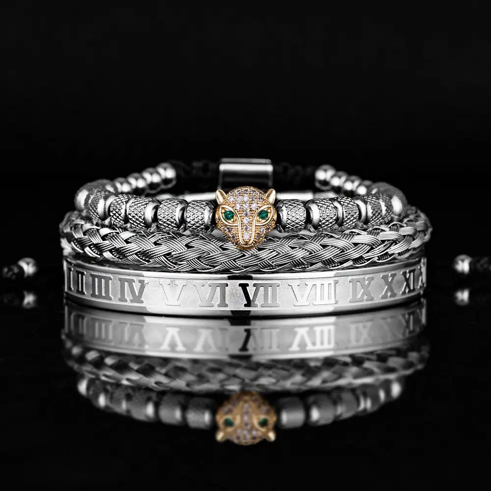 Stacked silver-toned roman numeral braided leather bracelets featuring a central golden panther head charm with green eyes and pave stones.