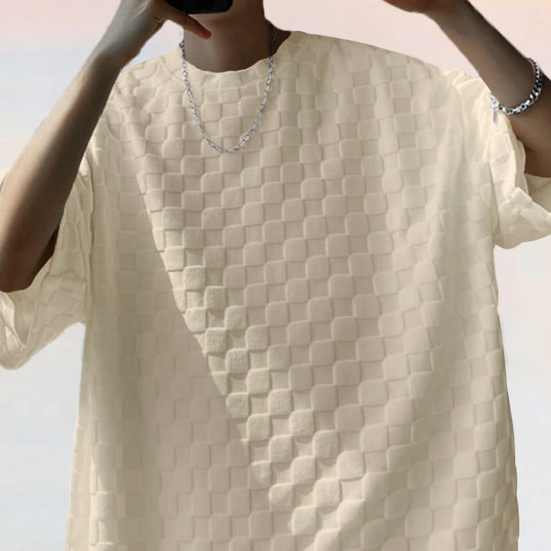 Off-white short-sleeved textured geometric cotton blend t-shirt featuring a quilted pattern of raised square shapes.