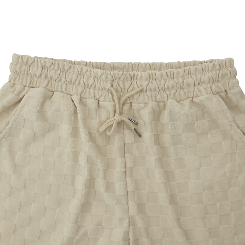Beige textured checkered joggers with an elastic waistband and matching drawstring made of cotton blend matching the textured geometric cotton blend t-shirt and shorts set.