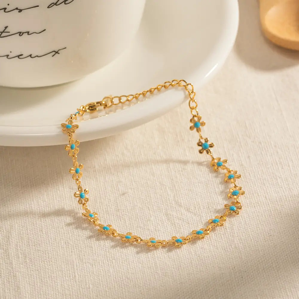 Gold-toned chain anklet adorned with delicate turquoise flower charms from the turquoise daisy gold chain necklace and bracelet set.