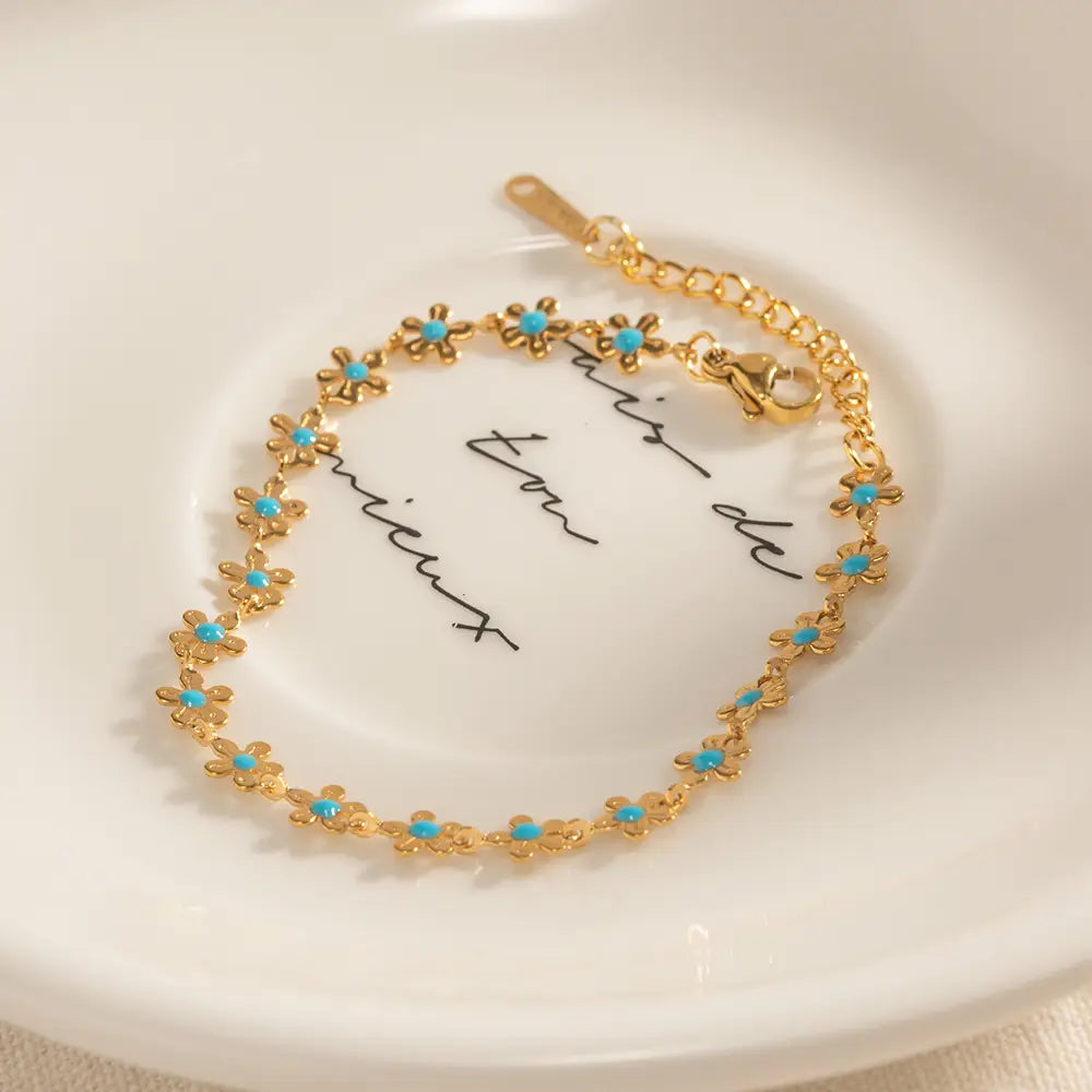 Gold-toned chain bracelet adorned with small turquoise flower charms from the turquoise daisy gold chain necklace and bracelet set.