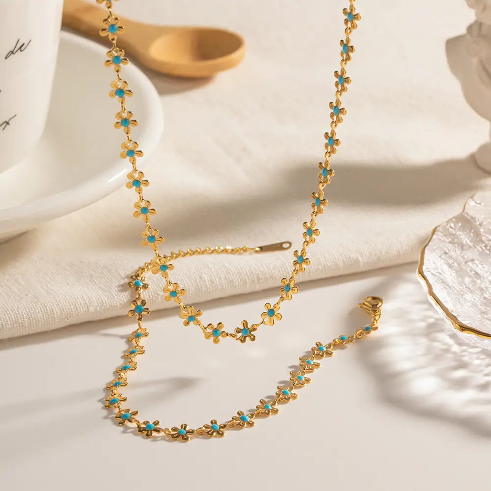 Gold chain necklace featuring delicate turquoise-centered daisy flower charms as part of a turquoise daisy gold chain necklace and bracelet set.