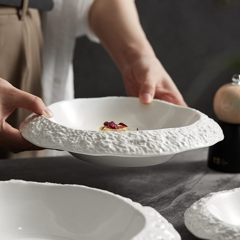 White ceramic deep bowl with a textured rocky rim and smooth interior ideal for modern tableware.