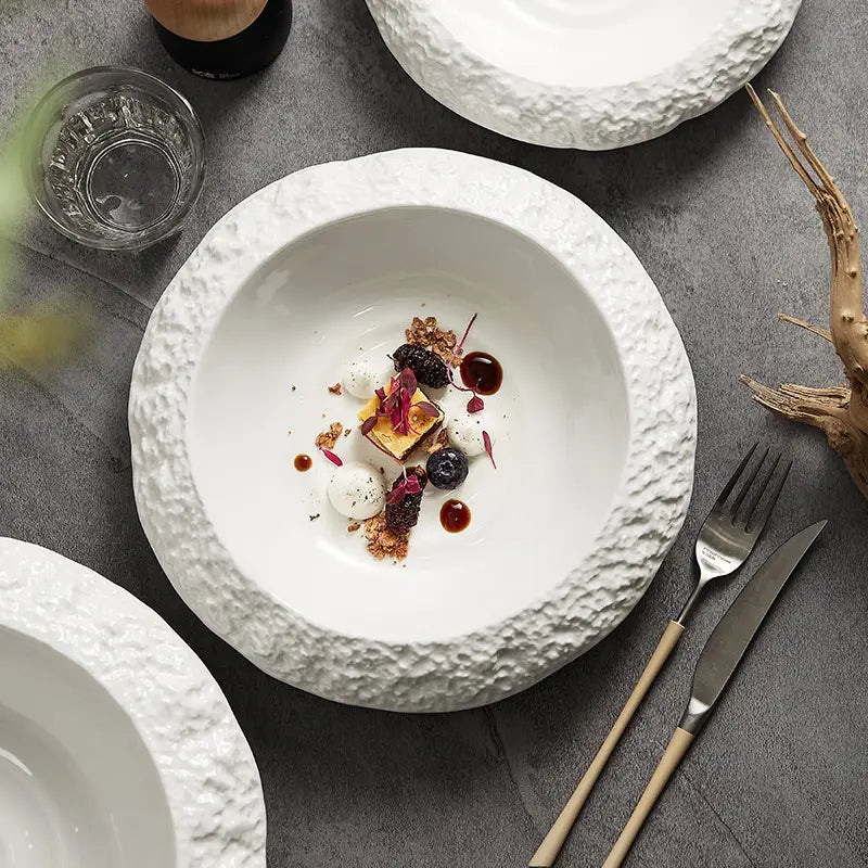 White ceramic deep bowl with a textured rocky surface featuring a modern rock pattern design