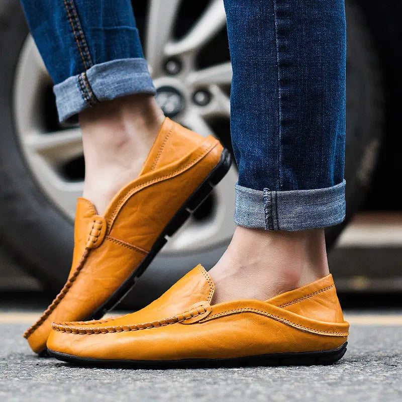 Herren-Lederschlupf-Loafer in Hellbraun mit einem gesteppten Mokassin-artigen Design und schwarzen Gummisohlen.