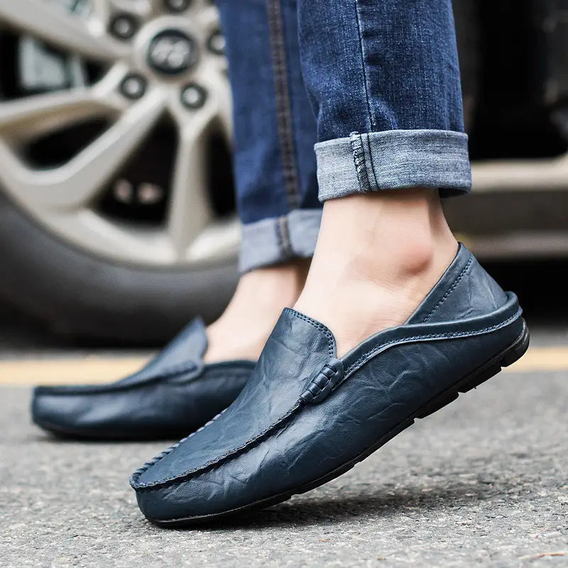 Dunkelblaue Lederschlupf-Loafer mit strukturierter Oberfläche und gestickten Details, ideal für Herren-Mokassins.