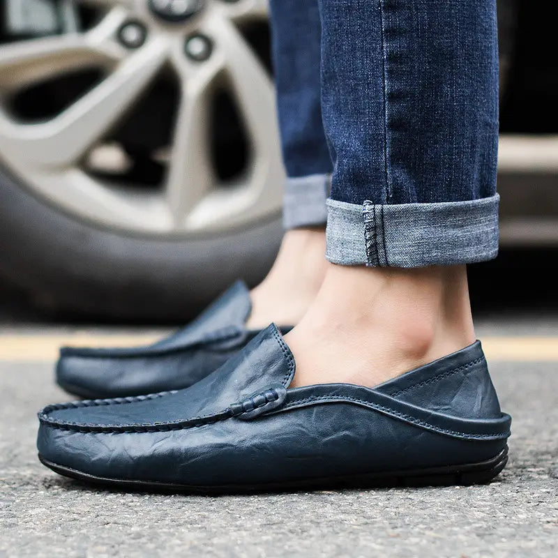 Herren-Lederschlupf-Loafer in Dunkelblau mit einem gesteppten Mokassin-artigen Design und schwarzen Gummisohlen.