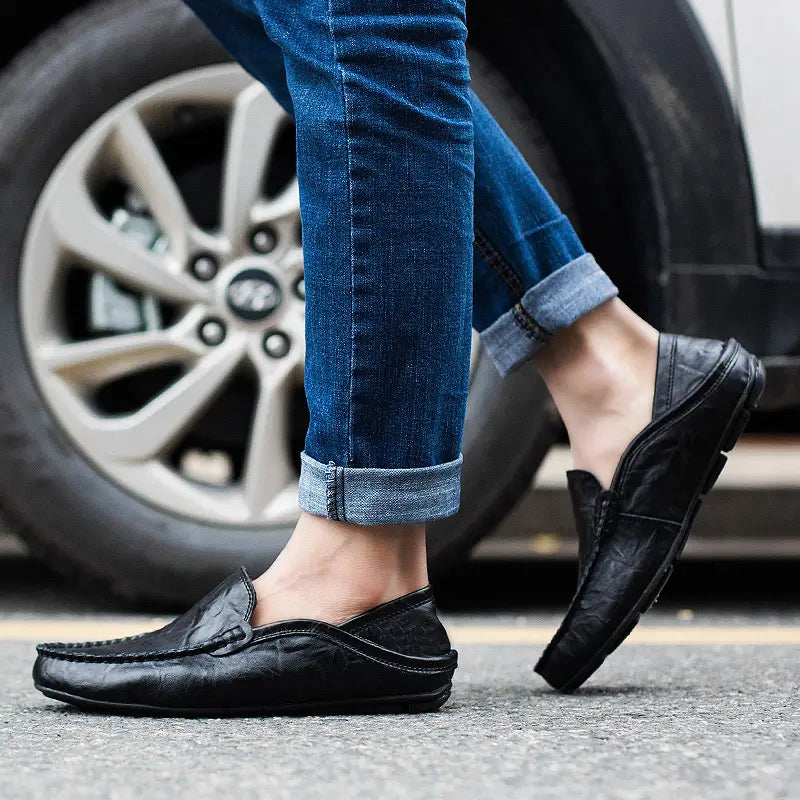 Schwarze Lederschlupf-Loafer für Herren mit strukturierter Oberfläche und gestickten Details.