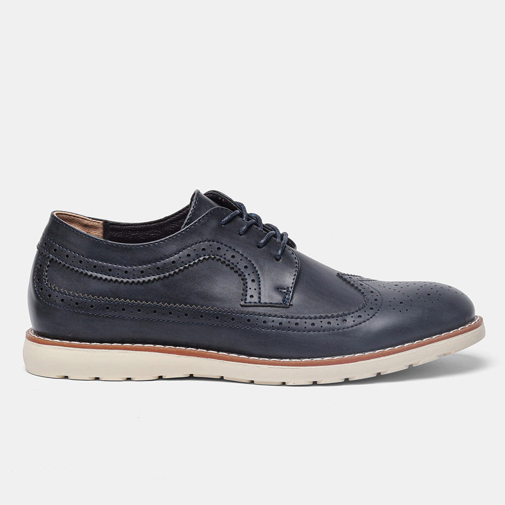 Men’s brogue casual leather sneakers in dark navy with perforated detailing and a contrasting tan sole made from lightweight leather.