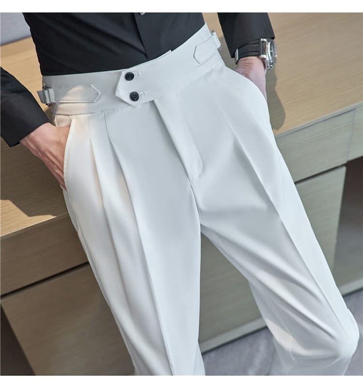 White high-waisted mens pleated drape casual trousers with a structured pleated design and a distinctive belt detail featuring black buttons.