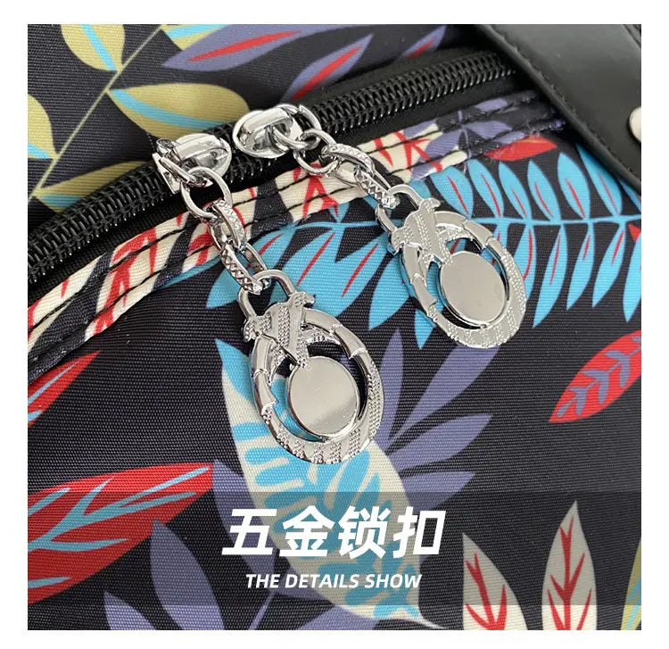 silver-toned metal zipper pulls with dangling ring-shaped charms attached by chain links on an oxford cloth floral messenger bag retro shoulder purse