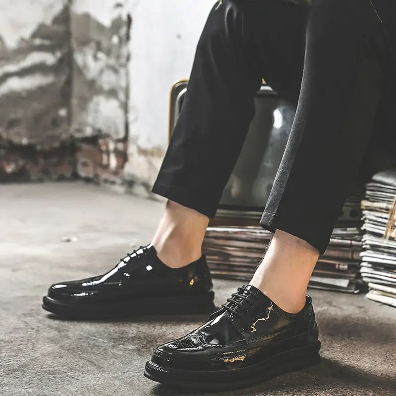 men’s black patent leather brogue oxford shoes with a glossy finish and subtle gold detailing on the toe cap designed for business casual wear with a chunky sole