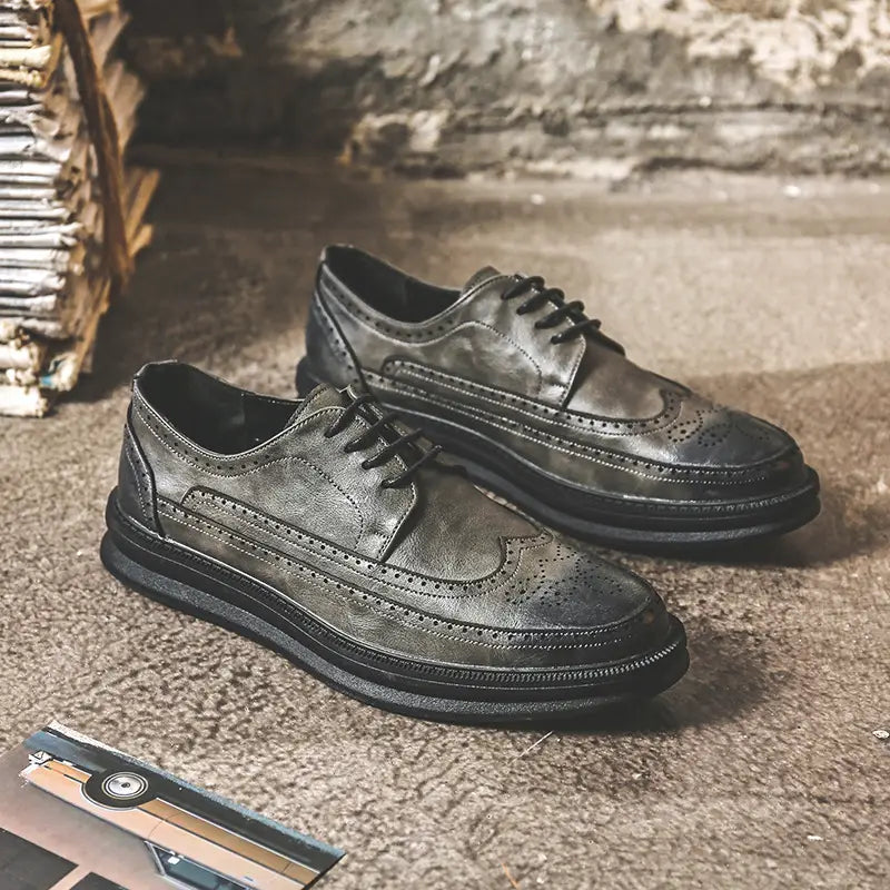 Dark gray leather men’s brogue Oxford shoes with black laces and a chunky rubber sole suitable for business casual wear.