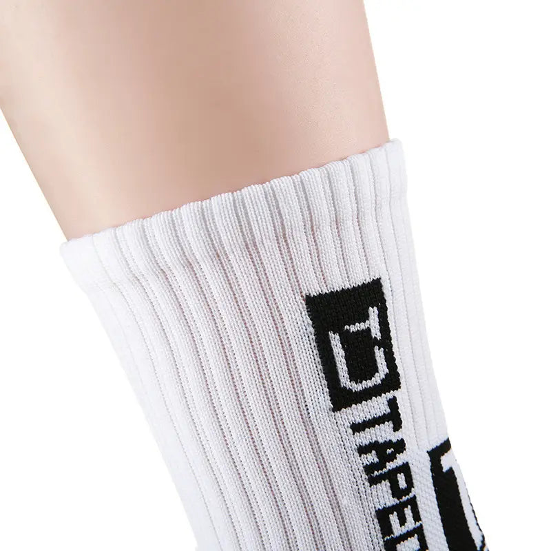 Chaussette de football antidérapante blanche, hauteur mi-mollet côtelée, avec logo d-tape noir imprimé verticalement sur le côté