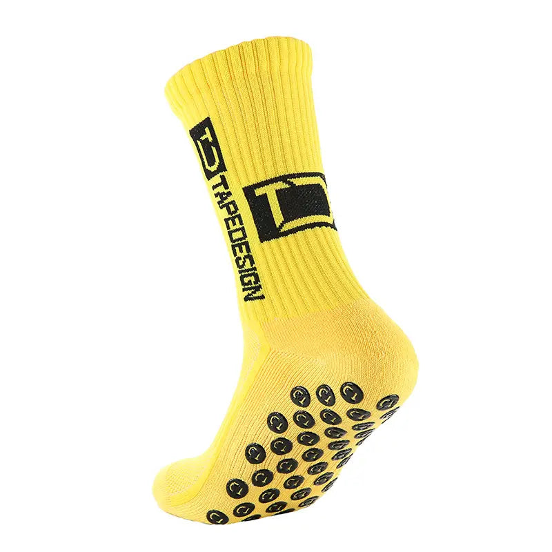 Chaussettes de football antidérapantes jaune vif avec pastilles circulaires texturées noires sur la semelle et un logo noir affirmé près de la manchette.