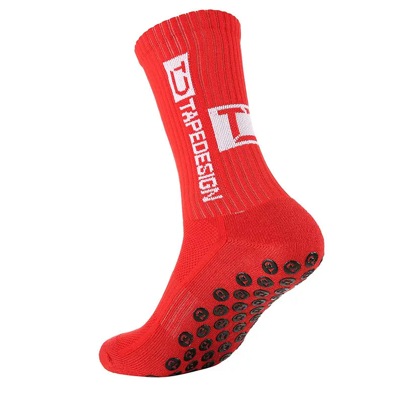 Chaussettes antidérapantes avec design de ruban rouge, de couleur rouge, comportant des pastilles de caoutchouc circulaires noires sur la semelle et un logo blanc sur la manchette pour un usage antidérapant.
