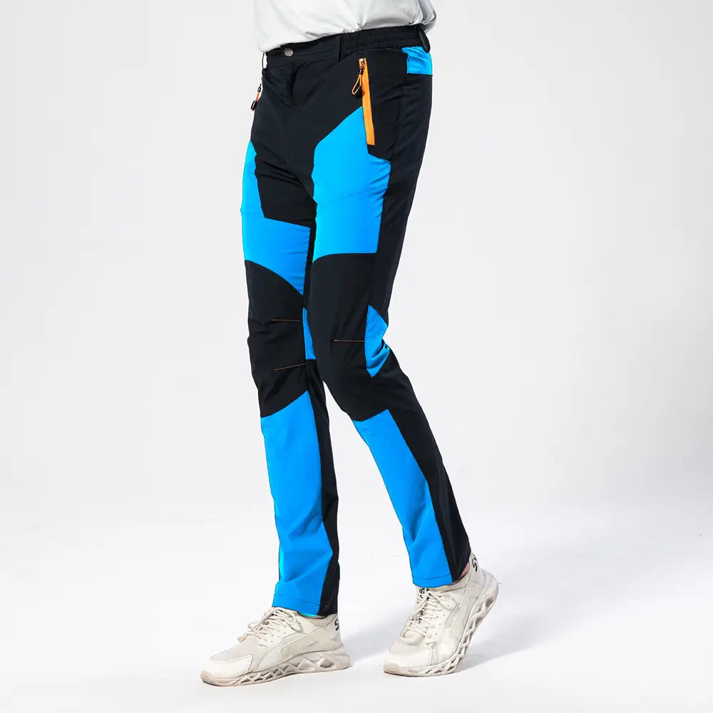 Men quick dry tactical hiking pants in black and bright blue with orange zipper accents designed for outdoor use.