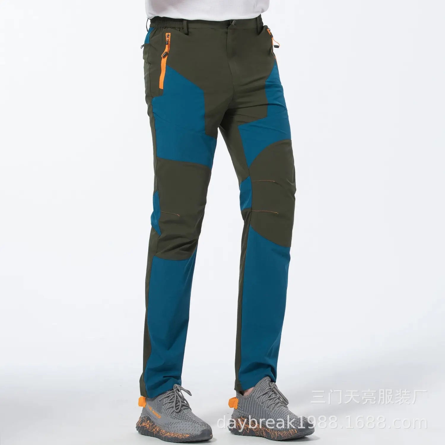 men quick dry tactical hiking pants in olive and teal color blocking with orange zipper accents designed for outdoor use