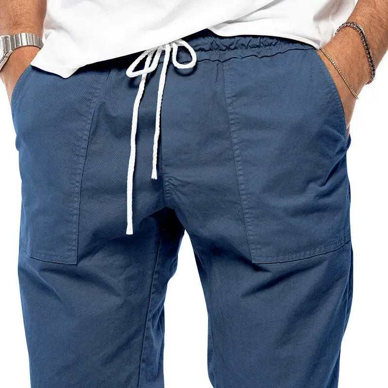 Joggeurs décontractés pour hommes à jambe fuselée bleu marine, avec cordon de serrage blanc et poches latérales, fabriqués dans un tissu confortable.