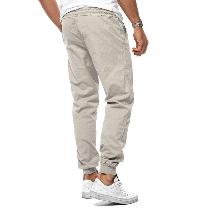 Joggeurs décontractés pour hommes à jambe fuselée beige en tissu cargo, avec une ceinture élastique et des chevilles resserrées.
