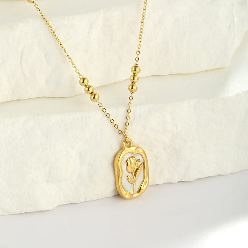18k gold plated stainless steel necklace featuring a gold-toned delicate tulip shell pendant within an oval frame accented by small spherical beads along the chain.